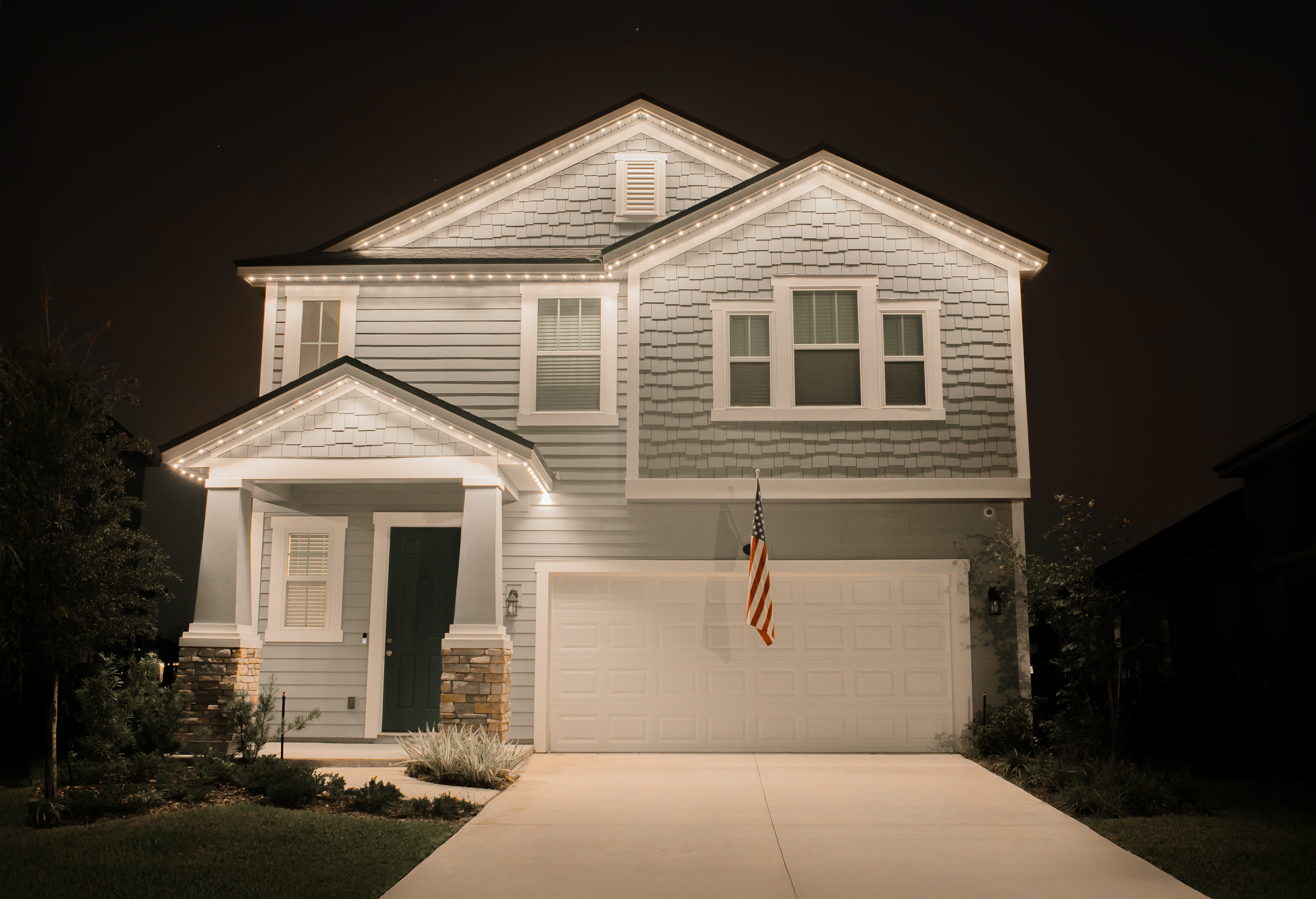 Residential home with holiday permanent lighting at night